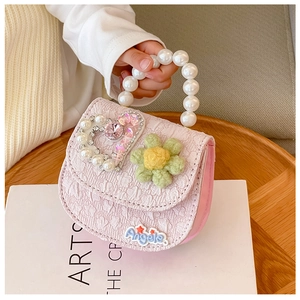 Detail of pink floral kids bag with pearl handle and rhinestone heart decoration