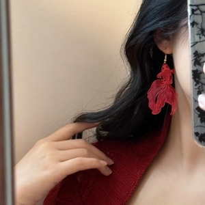 Macro shot of red koi goldfish drop earrings with intricate hollow fish tail textures