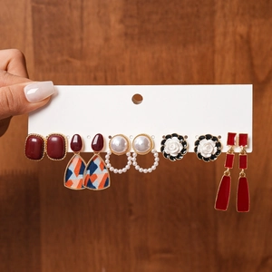 Detailed set of six resin pearl earrings in burgundy and gold geometric flower styles