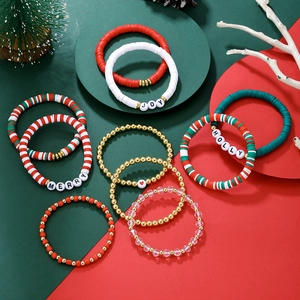 Détail de l'ensemble de bracelets de Noël avec perles d'argile rouges, vertes et lettres