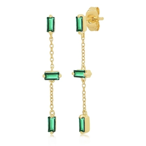 Detailed view of long gold drop earrings with three emerald green rectangular gemstones