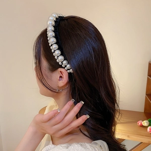 Detail of a French vintage black velvet headband with elegant pearls on a female model