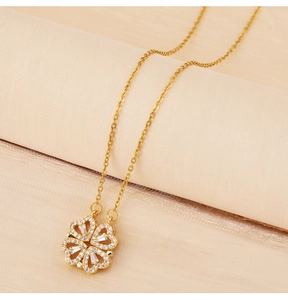 Close-up of gold clover necklace pendant with embedded sparkling clear crystals