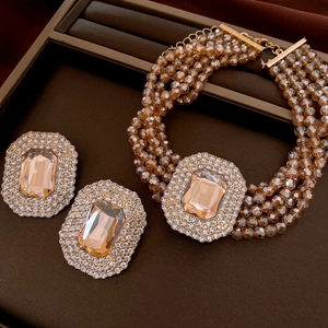 Detailed close-up of amber crystal necklace and matching earrings set in gold finish