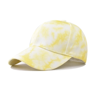 Close-up of yellow and white tie-dye cotton baseball cap with six-panel construction