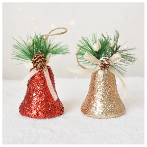 Cloches de Noël étincelantes avec aiguilles de pin et cônes sur neige blanche
