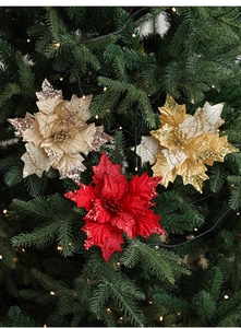 Sparkling sequin fabric Christmas flowers on green tree with warm festive lights