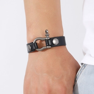 Close-up of men's black leather bracelet with vintage metal horseshoe buckle on wrist