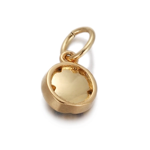 Macro shot of a polished gold-plated round pendant with shiny finish and hanging loop