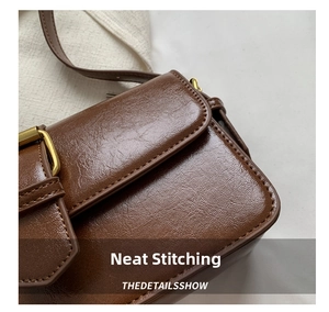 Detailed close-up of dark brown wax oil leather texture and neat stitching on shoulder bag