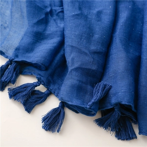 Detail of dark blue cotton linen scarf featuring fringe edges and subtle silver glitter