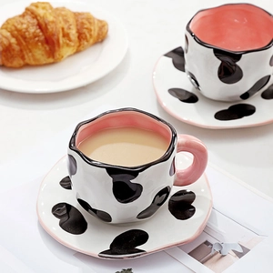 Handmade cow print ceramic coffee cup set with irregular edges and pink interior accent
