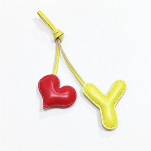 Detail view of handmade leather heart and Y letter charms with litchi grain texture
