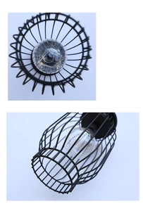 Detail view of industrial black metal cage lantern with warm LED string lights