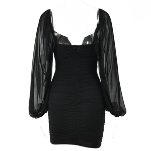 Detail of black mini dress featuring mesh lantern sleeves and ruching with a back zipper