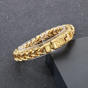 Close-up of gold stainless steel woven curb chain bracelet with retro engraved buckle