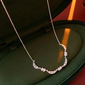 Close-up of silver floral pendant necklace inside a luxury green velvet jewelry box