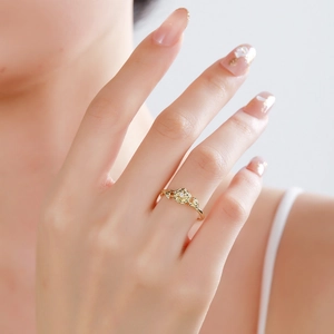 Minimalist gold birth flower ring with rose design and sparkling cubic zirconia on model finger