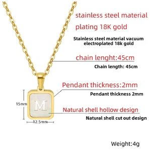 Détail d'un pendentif carré plaqué or 18K avec incrustation de nacre et gravure de lettre M
