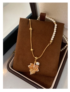 Detail of gold maple leaf necklace with sparkling crystals and elegant pearls