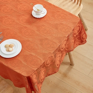 Close-up of vintage orange lace tablecloth featuring intricate 3D floral embroidery details