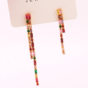 Close-up of long tassel earrings with colorful rectangular zircons and gold alloy base