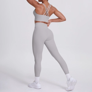 Vista posteriore del set yoga grigio chiaro con reggiseno incrociato e leggings a vita alta