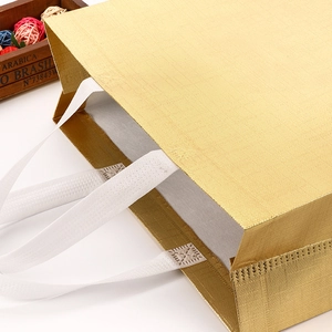 Detailed close-up of golden laser non-woven shopping bag with embossed square texture