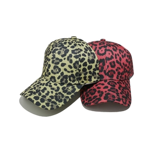 Detail showing two leopard print baseball caps in olive green and magenta colors