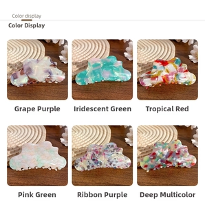 Cloud-shaped acetate claw clips displayed in six vibrant marbled colors on a wooden table