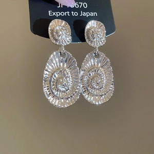 Detail of silver oval earrings with spiral texture showing ripple design and model JF4670