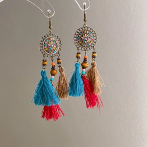 Detail of vintage bohemian earrings with colorful wood beads and cotton tassels