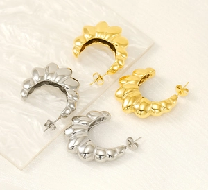Top view of gold and silver ribbed croissant stud earrings in a C-shape design