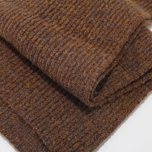 Close-up of thick caramel brown and navy striped chunky rib knit fabric texture