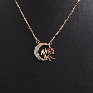 Détail macro du pendentif étoile et lune dorée avec pierres précieuses rouges et claires