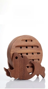 Detailed view of round ebony wood trivets stored on a creative fish-shaped wooden rack