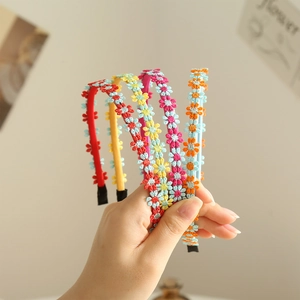 Close-up of five colorful daisy embroidered headbands with intricate floral patterns