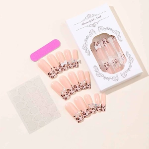 Detail of long leopard print press-on nails with white 3D bows and rhinestones