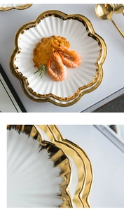 Detail of scallop shaped ceramic plates with gold rim featuring a textured shell design