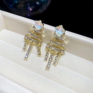 Macro shot of gold star drop earrings with spiral tassels and shimmering rhinestones