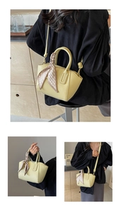 Detail of yellow lychee-textured bucket bag with stylish silk scarf and golden hardware