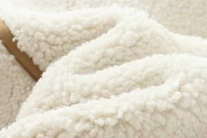 Macro shot of soft white faux shearling texture on a warm fleece jacket for women