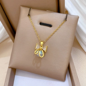 Elegant gold bow necklace with sparkling zircon and luminous bead on silk background