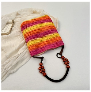 Detail of rainbow straw bucket bag with colorful gradient stripes and wooden bead handle