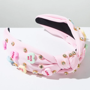 Detail of pink knotted headband with heart-shaped candy charms and sparkling rhinestones