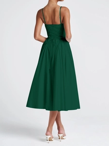 Detail of elegant dark green midi dress featuring thin spaghetti straps and back lace-up design