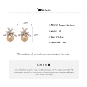 Detail view of champagne pearl earrings with zircon bow design and silver needles