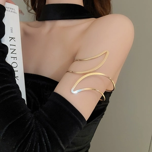 Gros plan d'un bracelet de bras minimaliste doré à double couche ondulée sur le haut du bras