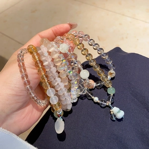 Detail of natural white chalcedony and yellow quartz beaded bracelet with charms