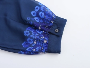 Detail of the elegant blue floral chiffon sleeve cuff with a single round button